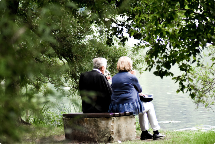 two older people facing a body of water