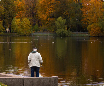 Older man looking out towards a lake.